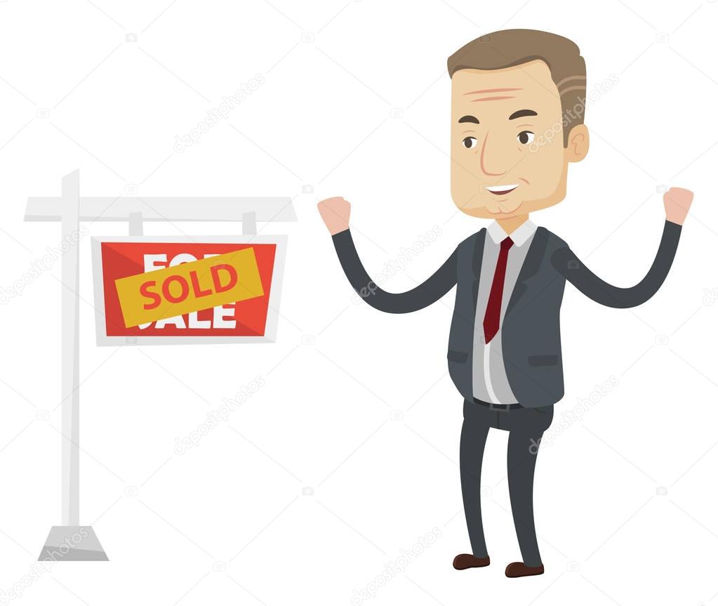 Agent standing near sold real estate sign.