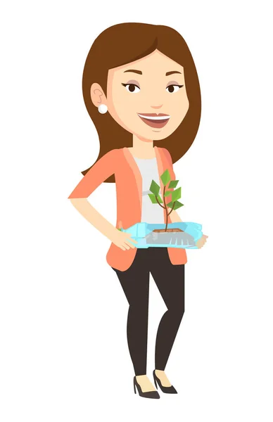 Mujer sosteniendo planta creciendo en botella de plástico . — Vector de stock