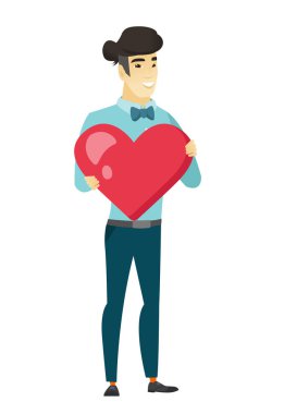 Büyük kırmızı bir kalp tutan Asya iş adamı.