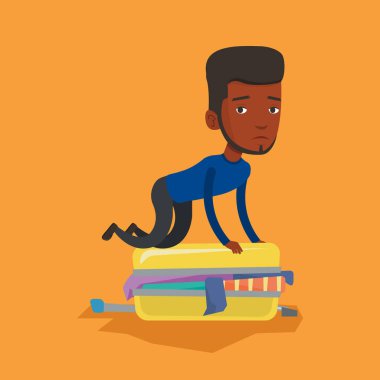 Genç adam bavul kapatmaya çalışırken.