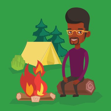 Günlük kamp, kamp ateşi yanında oturan adam.