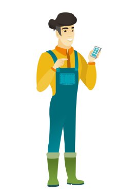 Asyalı çiftçi bir cep telefonu tutan.