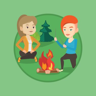 İki arkadaş kamp içinde şenlik ateşi etrafında oturan.