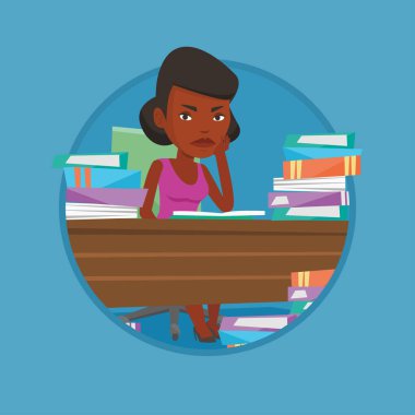 Kitap yığınları ile masadan öğrenci.