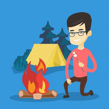 Genç adam hatmi kamp ateşi kavurma.