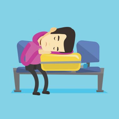 Yorgun adam havaalanında bavul üzerinde uyuyor.