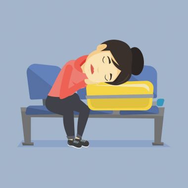 Havaalanında bavul üzerinde uyuyan yorgun kadın.