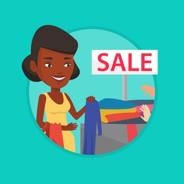 Genç kadın Satılık dükkan giysiler seçmek.