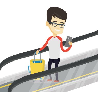 Havaalanında yürüyen merdiven üzerinde akıllı telefon kullanan adam.