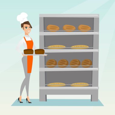 Mutlu genç baker ekmek ile bir tepsi tutarak.
