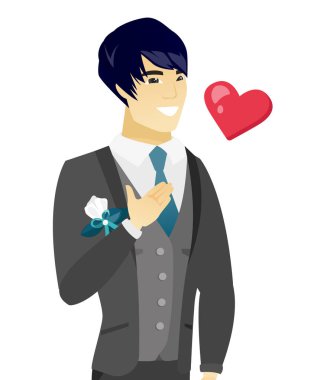 Genç Asyalı damat elini göğsüne tutarak.