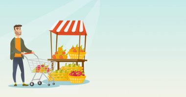 Beyaz delikanlı bir süpermarket arabası itme.