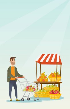 Beyaz delikanlı bir süpermarket arabası itme.