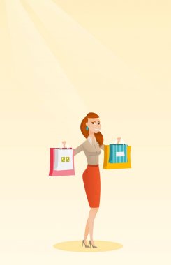 Alışveriş torbaları tutan genç beyaz kadın.