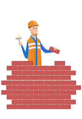 Genç Duvarcı ustası spatula ve tuğla ile çalışma.