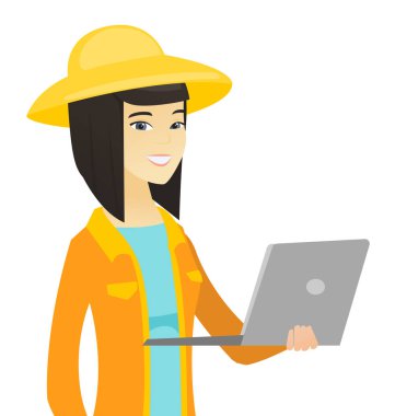 Genç Asyalı çiftçi bir dizüstü bilgisayar kullanarak.