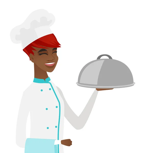 Jonge Afrikaanse chef-kok holding handdoek en cloche. — Stockvector