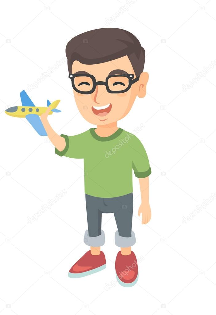 Caucasian cheerful boy playing with a toy airplane