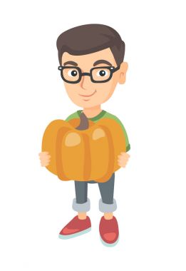 Beyaz çocuk büyük bir turuncu kabak ile ayakta.