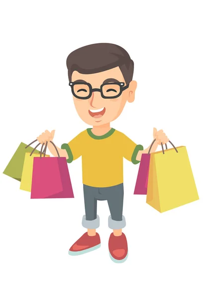 Menino caucasiano feliz segurando sacos de compras . — Vetor de Stock