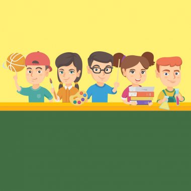 Okul malzemeleri ile masada duran çocuklar.