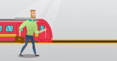 Bir tren istasyonu platformu üzerinde yürüyen genç adam.