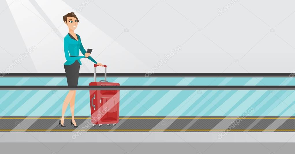 Woman using smartphone on escalator at the airport