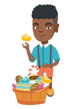 Bir cupcake tutarak ve karnına okşayarak çocuk.