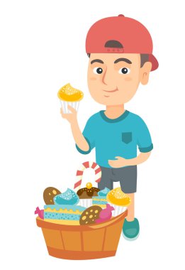Bir cupcake tutarak ve karnına okşayarak çocuk.