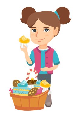 Bir cupcake tutarak ve karnı okşayarak kız.