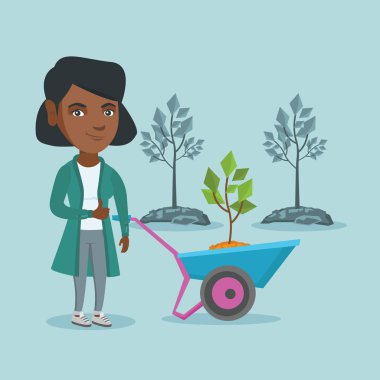 Afrikalı kadın üretim tesisi ile el arabası itme.