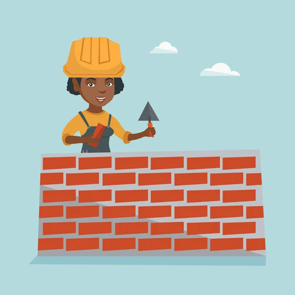Jovem pedreiro africano construindo uma parede de tijolo . —  Vetores de Stock