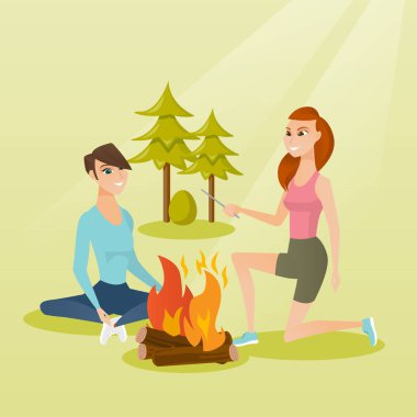 İki arkadaş kamp içinde şenlik ateşi etrafında oturan.