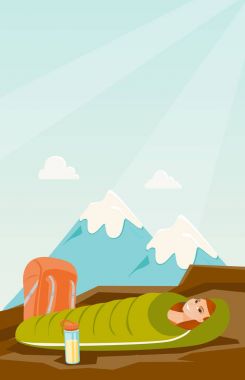 Dağlarda bir uyku tulumu içinde uyuyan kadın.