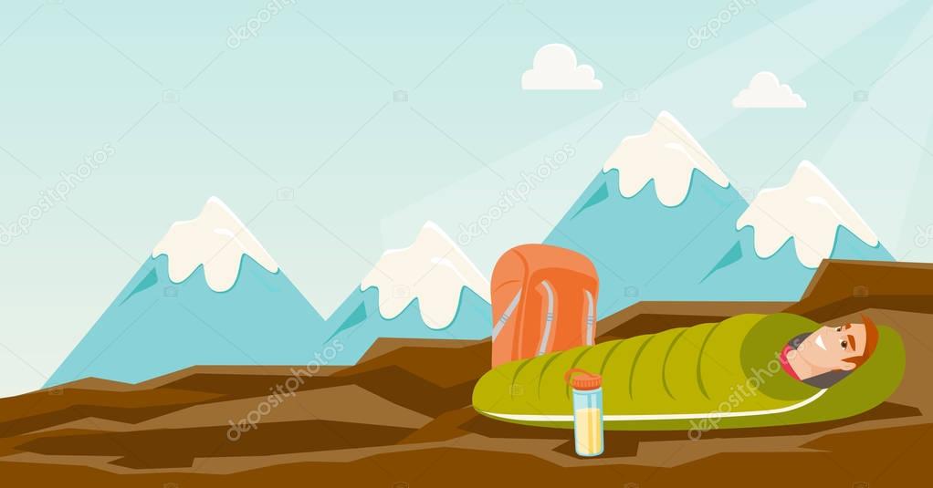 Man sleeping in a sleeping bag in the mountains.