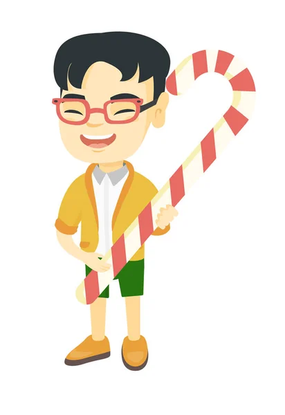 Asiático menino segurando Natal doce cana . — Vetor de Stock