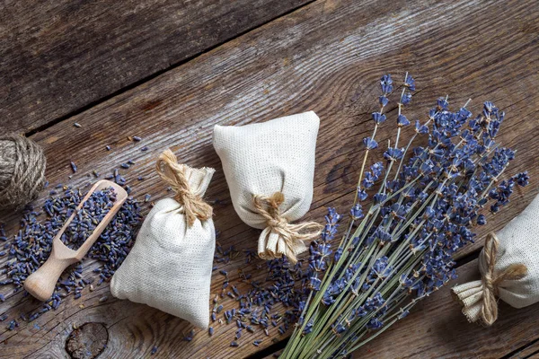 Bando de flores de lavanda e três saquetas cheias de lavanda — Fotografia de Stock