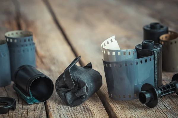 Rolos de filme de foto vintage e cassete na mesa de madeira velha . — Fotografia de Stock