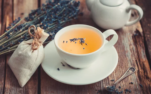 Gäng lavendelblommor, te i koppen, Tekanna och dospåse — Stockfoto
