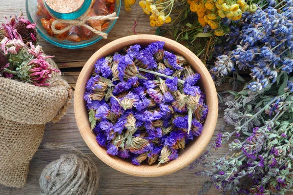 Лекарственные травы, раствор и мешок сухих здоровых цветов на столе — стоковое фото