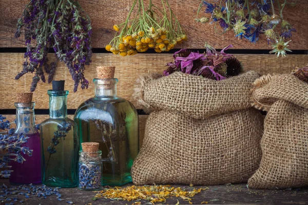 Herbes de guérison dans des sacs de Hesse, des grappes d'herbes médicinales et des bouteilles de teinture — Photo