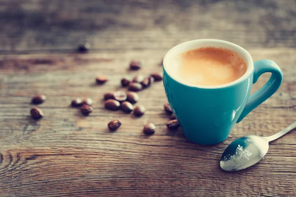 Espresso coffee cup with beans on wooden board. Retro stylized. — Stock Photo, Image