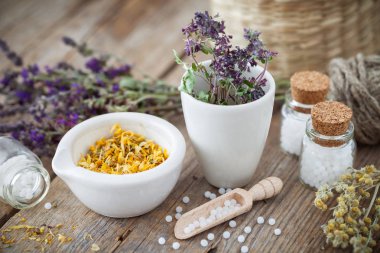 Harç ve kurutulmuş şifalı otlar kase ve Homeopatik globüller şişe. Homeopati tıp kavramı.