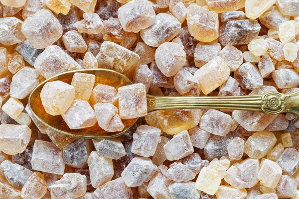 Gekarameliseerde bruine suiker in lepel. Rietsuiker kubussen achtergrond. — Stockfoto