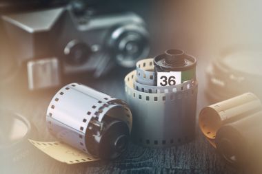 Eski fotoğraf film rulo ve arka plan üzerinde retro kamera. Bir parlama efekti ile stilize vintage.