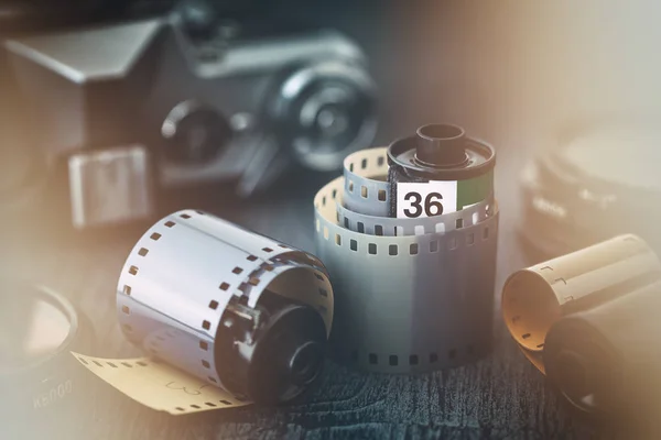 Old photo film rolls and retro camera on background. Vintage stylized with a glow effect. — Stock Photo, Image