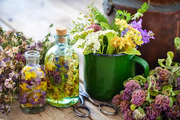 Tasse émaillée d'herbes cicatrisantes, vieille bouilloire, bouteilles de teinture ou d'huile d'herbes et plantes médicinales pour une tisane saine. Médecine végétale . — Photo