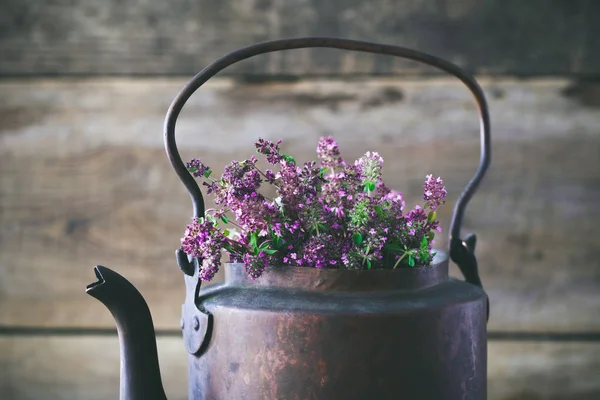 ビンテージの素朴なお茶ポット健康ハーブ茶のタイムの花でいっぱい。漢方薬. — ストック写真