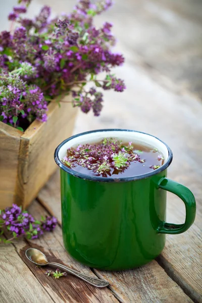 Эмалированная кружка из тимьяновых целебных трав и деревянная коробка, полная тимуса serpyllum для здорового травяного чая. Травяная медицина . — стоковое фото