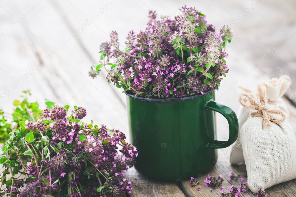 Enameled mug of thyme healing herbs and sachet. Herbal medicine.